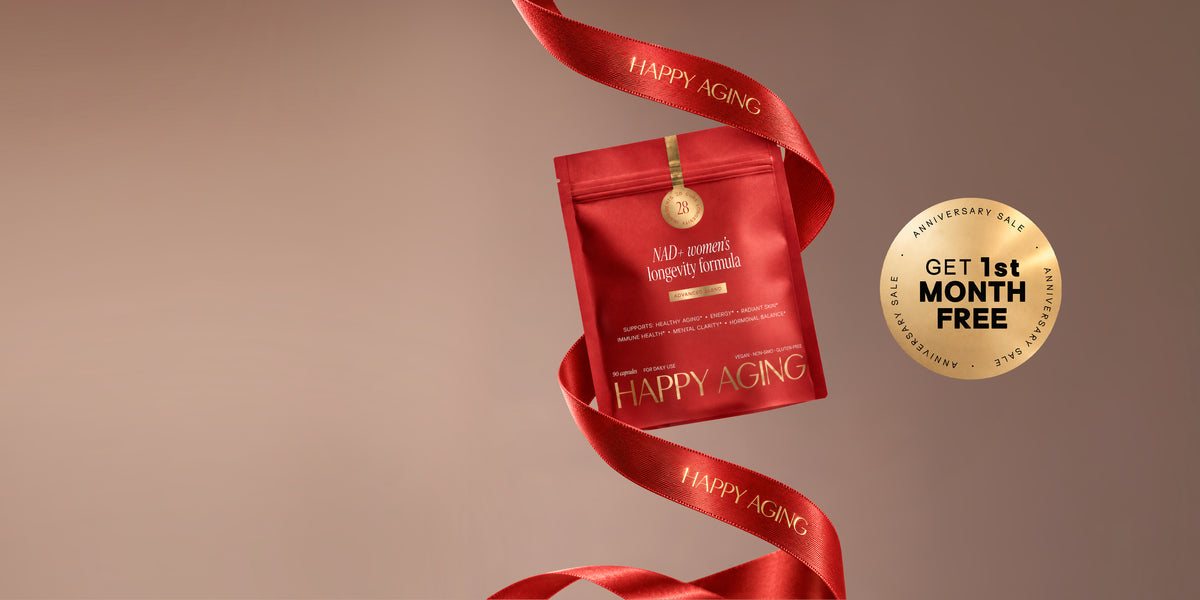 Two red Happy Aging NAD+ women's longevity formula pouches with a black ribbon and a gold Anniversary Sale seal on a warm brown background.
