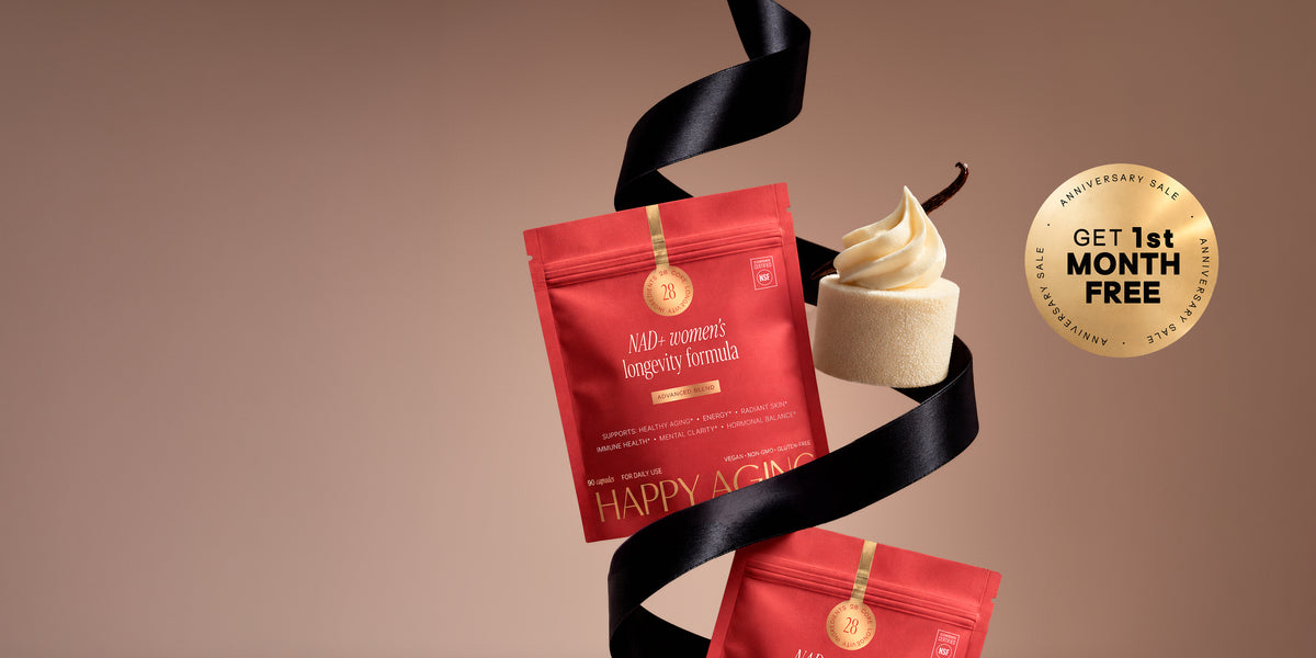 Two red Happy Aging NAD+ women's longevity formula pouches with a black ribbon and a gold Anniversary Sale seal on a warm brown background.